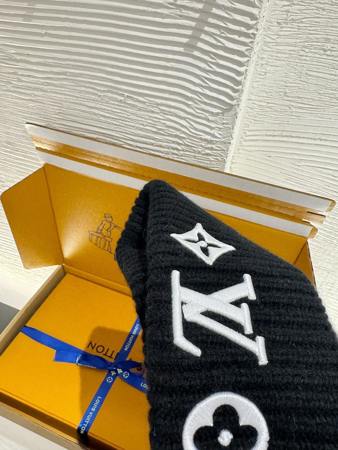 LOUIS VUITTON new embroidered wool cold hat ●Original version: 3800 purchase and development ●Item number: 1681973-A45 ●Fabric: wool blended fabric ●Technology: embroidery production ●Color: white/black ●Version: fitted version ●Description: This is LV The 2025 autumn and winter series logo embroidered knitted cold hat is made of 100% Italian virgin wool, woven with a 30-needle dense weaving process. The yarn twist reaches 600 twists/meter, which has both warmth and stiffness. The main body of the hat has a vertical grooved texture, which is elastically wrapped through fixed-spacing stitching techniques. The front logo of the hat uses three-dimensional appliqué technology, and the Monogram elements (quatrefoil, LV letters) are sewn with high-density embroidery threads of the same color. The edges are overlocked to prevent fuzzing and threading; the top of the hat is made of double-layer ribbing, which is durable and elastic and fits the ears. The finished product is shaped by high-temperature steam, and the three-dimensional shape of the hat is not easily deformed. The post-finishing process includes anti-static treatment, making it more comfortable for daily wear. The lining of the packaging is printed with the brand's classic "luggage maker" pattern, continuing the brand's retro luxury tone. The overall wiring is straight and delicate, the fabric is comfortable and soft, and the color is consistent without color difference. It can be matched with the same style to create a fashionable look and control various occasions. Customized accessories, complete with three standards, same style for men and women!